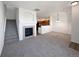 Open-concept living room with fireplace, staircase, and view of the adjacent kitchen area at 12713 Leyden St # E, Thornton, CO 80602