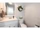 Bathroom features a white vanity, a mirror, toilet, towel and decorative wreath for a welcoming ambiance at 1537 S Owens St # 31, Denver, CO 80232