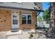Inviting townhouse entrance with brick facade, decorative bench, and well maintained landscaping at 1537 S Owens St # 31, Denver, CO 80232