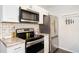Kitchen boasting white cabinets, subway tile backsplash, and stainless steel appliances at 1537 S Owens St # 31, Denver, CO 80232