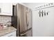 Close-up of a stainless steel refrigerator and white cabinets in the well-lit kitchen at 1537 S Owens St # 31, Denver, CO 80232