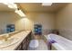 Bathroom with dual sinks, framed mirrors, and a soaking tub with tile surround at 262 Yank Ct, Lakewood, CO 80228
