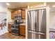 Updated kitchen showcasing stainless steel refrigerator, wooden cabinets, and modern appliances at 262 Yank Ct, Lakewood, CO 80228