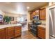 Well-lit kitchen with wood cabinets, stainless steel appliances, and an adjacent dining area at 262 Yank Ct, Lakewood, CO 80228