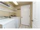 Functional laundry room includes washer, dryer, shelving, and access door at 262 Yank Ct, Lakewood, CO 80228