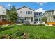 Landscaped backyard featuring a lawn, patio with a hot tub, grill and chairs, set in front of a two-story home at 800 Meadowlark Dr, Erie, CO 80516