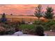 Picturesque backyard with colorful flowers, lush greenery, and a charming wooden fence under a vibrant sky at 800 Meadowlark Dr, Erie, CO 80516
