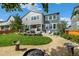 Expansive backyard featuring a covered patio, lush lawn, mature trees, gravel pathway, and grilling area at 800 Meadowlark Dr, Erie, CO 80516