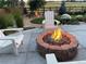 Inviting backyard with a stone fire pit, Adirondack chairs, and landscaped surroundings, perfect for outdoor relaxation at 800 Meadowlark Dr, Erie, CO 80516