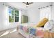 Cozy bedroom with a large window, natural light, ceiling fan, and stylish bed quilt at 800 Meadowlark Dr, Erie, CO 80516