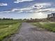 Picturesque gravel walking path leading into sprawling green space, sprinkler system watering grass near new construction homes at 800 Meadowlark Dr, Erie, CO 80516