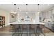 Bright kitchen featuring a large island with seating, modern pendant lights, stainless appliances, and wood flooring at 800 Meadowlark Dr, Erie, CO 80516