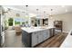 Bright kitchen island with stainless dishwasher and modern lighting overlooking the living area at 800 Meadowlark Dr, Erie, CO 80516
