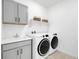 Bright laundry room is equipped with sink, storage and washer and dryer at 800 Meadowlark Dr, Erie, CO 80516