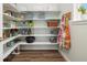 Walk-in pantry featuring ample shelving for organization, complete with wood flooring and an apron hanger at 800 Meadowlark Dr, Erie, CO 80516