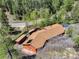 Aerial view showcases a home with brown roof surrounded by lush green trees at 11220 S Deer Creek Rd, Littleton, CO 80127