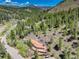 An aerial view of a cozy home nestled in a lush, green mountain landscape at 11220 S Deer Creek Rd, Littleton, CO 80127
