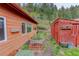 View of the backyard featuring multiple sheds and raised garden beds at 11220 S Deer Creek Rd, Littleton, CO 80127