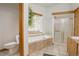 Bathroom featuring a walk-in shower and a soaking tub next to a bright window at 11220 S Deer Creek Rd, Littleton, CO 80127