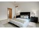 Cozy bedroom with neutral walls, stylish nightstands, lamps, a large bed, and tile flooring at 11220 S Deer Creek Rd, Littleton, CO 80127
