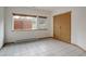 Clean bedroom with tile flooring, closet, window, and baseboard heating at 11220 S Deer Creek Rd, Littleton, CO 80127