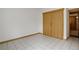 Bright bedroom with tile flooring, and closet; neutral walls and baseboard heating at 11220 S Deer Creek Rd, Littleton, CO 80127