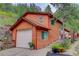 Charming home featuring wood siding, attached garage, and picturesque landscaping at 11220 S Deer Creek Rd, Littleton, CO 80127