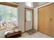 Bright foyer featuring tiled floor, closet, a window with wood pile, and decorative front door at 11220 S Deer Creek Rd, Littleton, CO 80127