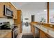 Bright kitchen featuring stainless steel appliances, granite countertops, and an open dining area at 11220 S Deer Creek Rd, Littleton, CO 80127