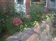 Landscaped flower garden featuring a variety of colorful blooms and a charming stone retaining wall at 11220 S Deer Creek Rd, Littleton, CO 80127
