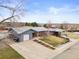 An aerial view showing the brick home, surrounding neighborhood, and mature trees at 6671 Chase St, Arvada, CO 80003