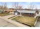 A wide exterior view of the home's front yard, showcasing its charming curb appeal at 6671 Chase St, Arvada, CO 80003