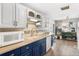 Well-lit kitchen with a combination of white and blue cabinets and mosaic backsplash at 6671 Chase St, Arvada, CO 80003