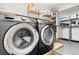 Laundry room showcasing modern appliances and functional shelving for organization at 6671 Chase St, Arvada, CO 80003