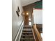 Carpeted staircase with wooden railing, leading to the upper level of the home at 6836 W 84Th Cir # 15, Arvada, CO 80003
