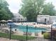 Relaxing swimming pool with lounge chairs, umbrellas, and lovely community gray buildings at 6836 W 84Th Cir # 15, Arvada, CO 80003