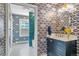 Stylish bathroom featuring patterned wallpaper, tiled shower, white countertop, and decorative lighting at 3330 E Tennessee Ave, Denver, CO 80209