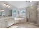 Bathroom with a soaking tub, shower, natural light, and dual sinks at 3330 E Tennessee Ave, Denver, CO 80209