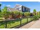 Beautiful two-story home with brick accents, lush landscaping, and a charming fence at 3330 E Tennessee Ave, Denver, CO 80209