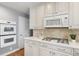 Bright kitchen with double ovens, gas cooktop, white cabinets, and quartz countertops at 3330 E Tennessee Ave, Denver, CO 80209