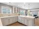 The open kitchen features quartz countertops, white cabinets, hardwood flooring, and stainless steel appliances at 3330 E Tennessee Ave, Denver, CO 80209
