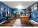 Home office space with eclectic blue walls, hardwood floors, and a vintage style wooden desk at 3330 E Tennessee Ave, Denver, CO 80209