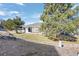 A view of the spacious backyard and patio, framed by mature trees and a well-manicured lawn at 2059 June Ct, Castle Rock, CO 80104