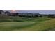 Scenic golf course view with lush green fairways, manicured greens, and a beautiful community backdrop at sunset at 2059 June Ct, Castle Rock, CO 80104