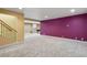 The finished basement offers carpet and a purple accent wall with a nearby staircase at 5460 S Locust St, Greenwood Village, CO 80111