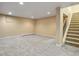 A spacious finished basement with neutral carpet and a staircase at 5460 S Locust St, Greenwood Village, CO 80111