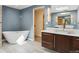 Bathroom features a soaking tub, modern vanity, updated fixtures, and stylish tiling at 5460 S Locust St, Greenwood Village, CO 80111
