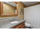 A cozy bathroom with a stone counter, wood-framed mirror, and shower-tub combo at 5460 S Locust St, Greenwood Village, CO 80111