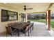 Covered patio includes a large dining table and ceiling fan overlooking the backyard at 5460 S Locust St, Greenwood Village, CO 80111