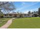 Ranch-style home with a green lawn, mature trees, stone walkway, and double door entry at 5460 S Locust St, Greenwood Village, CO 80111